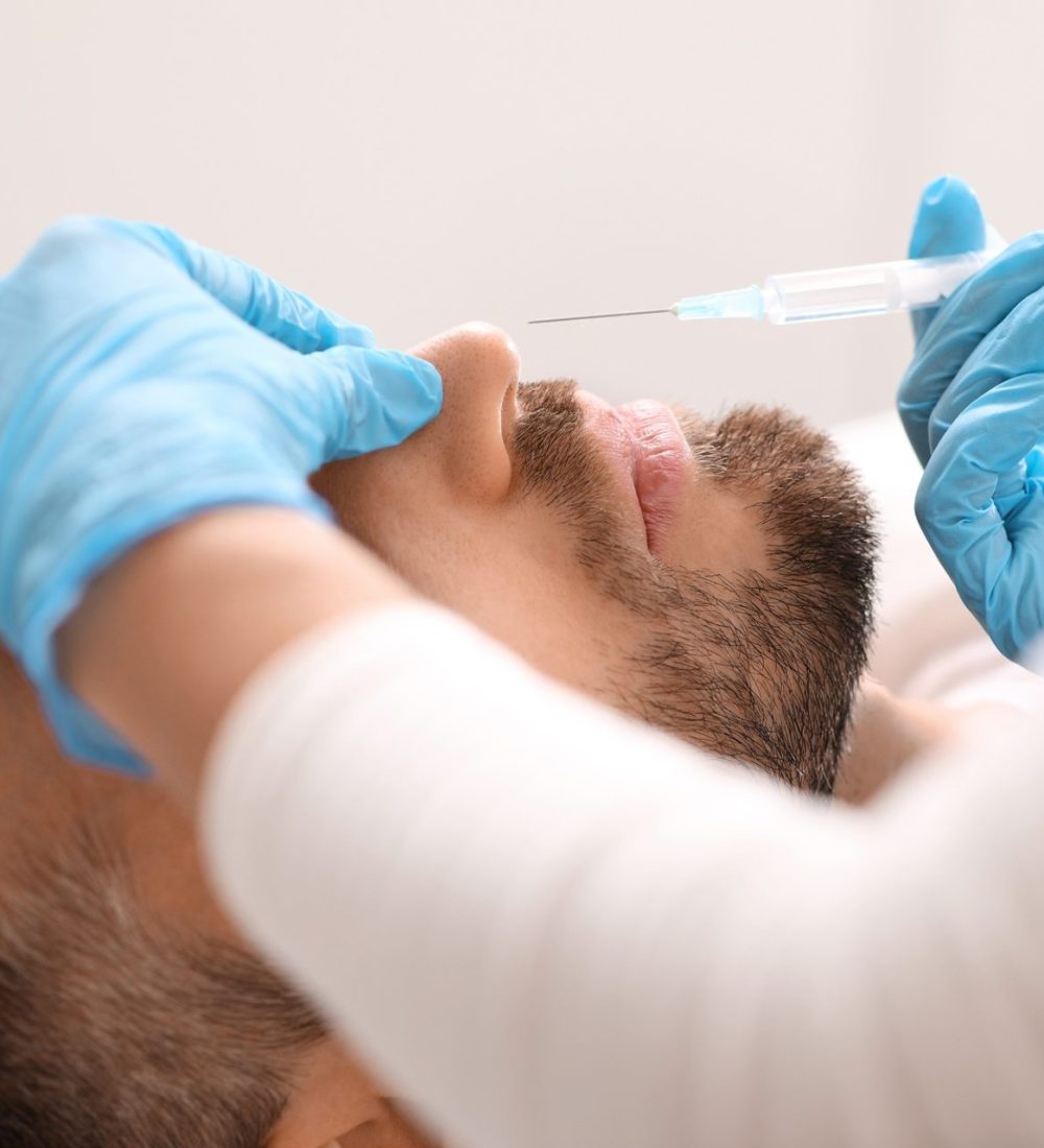 Closeup of plastic surgeon making nonsurgical rhinoplasty, injecting filler Closeup of plastic surgeon making nonsurgical rhinoplasty, injecting filler